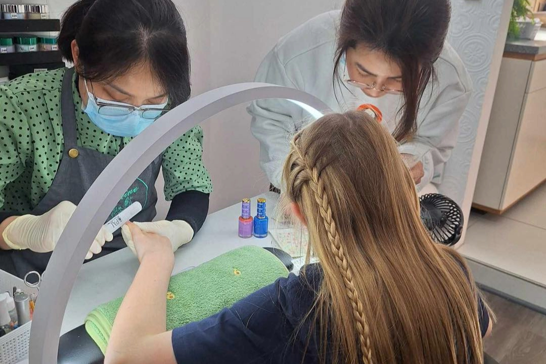 Kid enjoying a bright nail color session with family